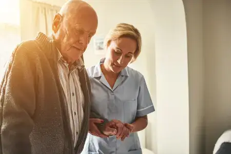 A carer helping an elderly gentleman